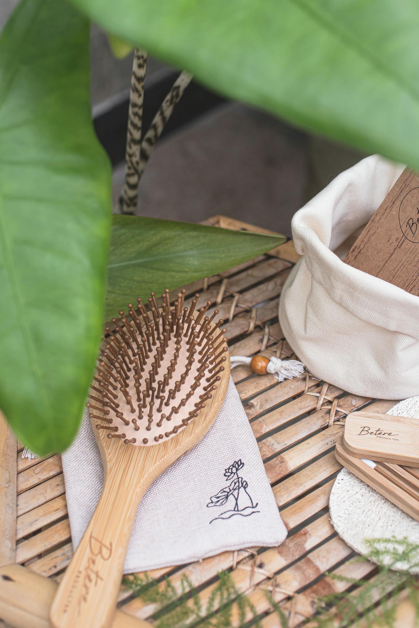 Eco-friendly wooden hairbrush with pouch on bamboo mat, promoting zero waste lifestyle.