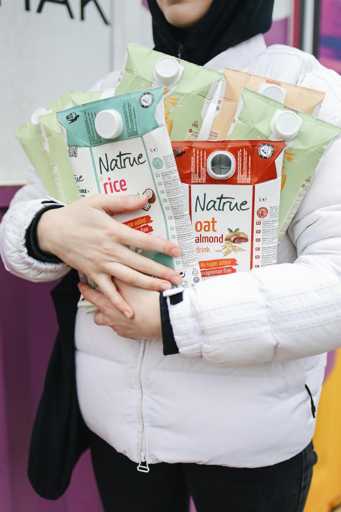 Person holding various eco-friendly beverage cartons showcasing sustainability.